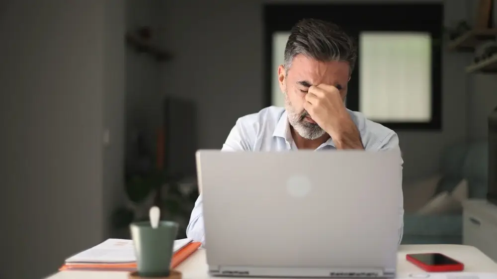 erschoepfter mann homeoffice laptop stress 1